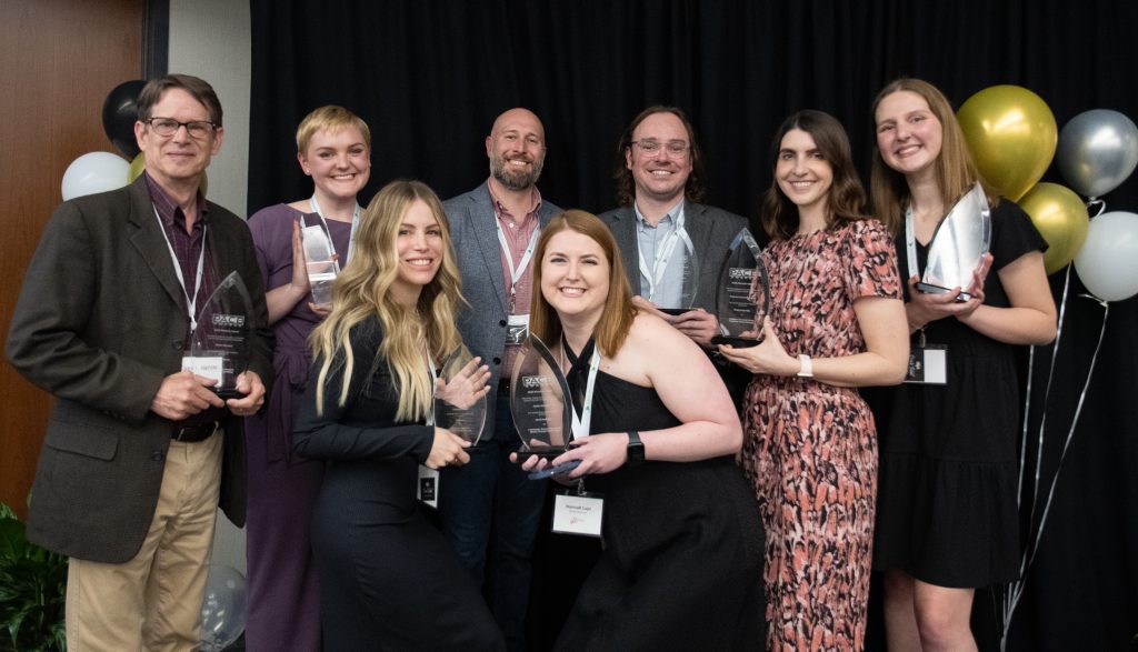 Martin Waymire staff photo at PACE awards ceremony holding awards