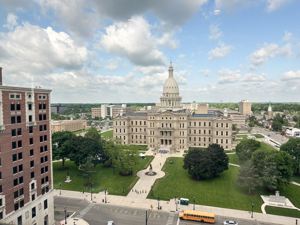 Landscape photo of Michigan State Capitol building with lawn and landscaping